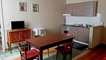 A compact kitchen with wooden cabinets, a dining table, and chairs.