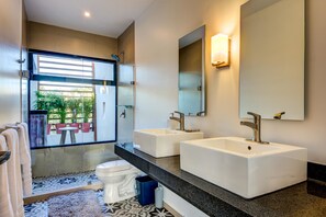A modern bathroom with two large white sinks, a toilet, and a glass shower enclosure. - Villa Doce Magnificent 3 BDRM sleeps 6 (Tulum)