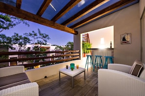 An outdoor patio with wicker furniture, a small table, and bar stools. - Villa Doce Magnificent 3 BDRM sleeps 6 (Tulum)