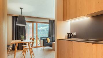 Una cucina moderna con mobili in legno, un'area pranzo con tavolo e sedie, e un divano.