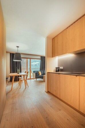 Une cuisine moderne avec des meubles en bois, un coin repas comprenant une table et des chaises, et un canapé.