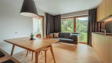 Una cucina moderna con zona pranzo, divano e vista su una foresta.