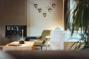 Een woonkamer met een televisie, een plant en een bank.