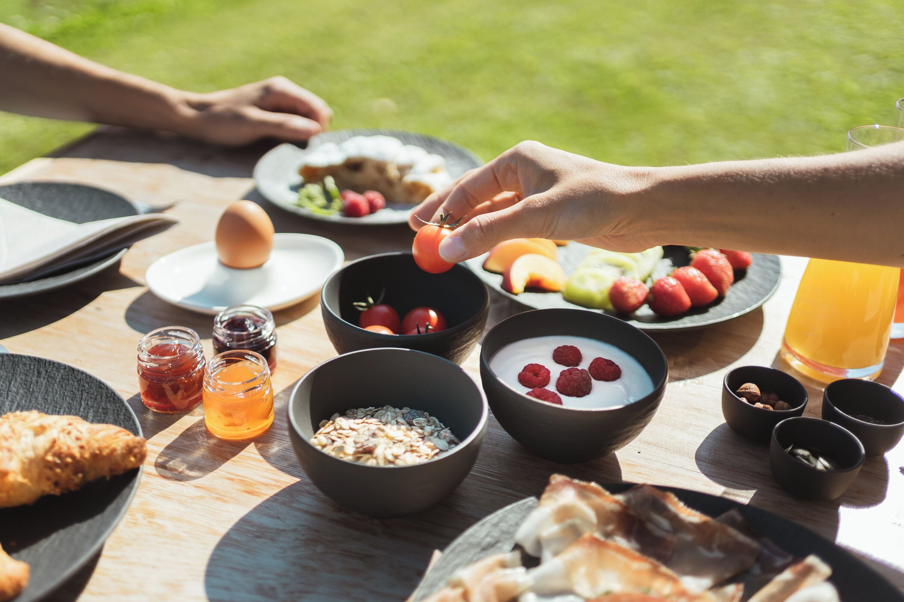 A breakfast setting with various food items and beverages on a wooden table.