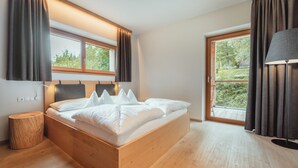 Een moderne slaapkamer met een houten bed, grote ramen en uitzicht op groen.