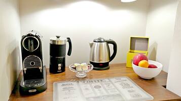 Eine Küchenarbeitsplatte mit Kaffeemaschine, Wasserkocher, Obstschale und Speisekarte.