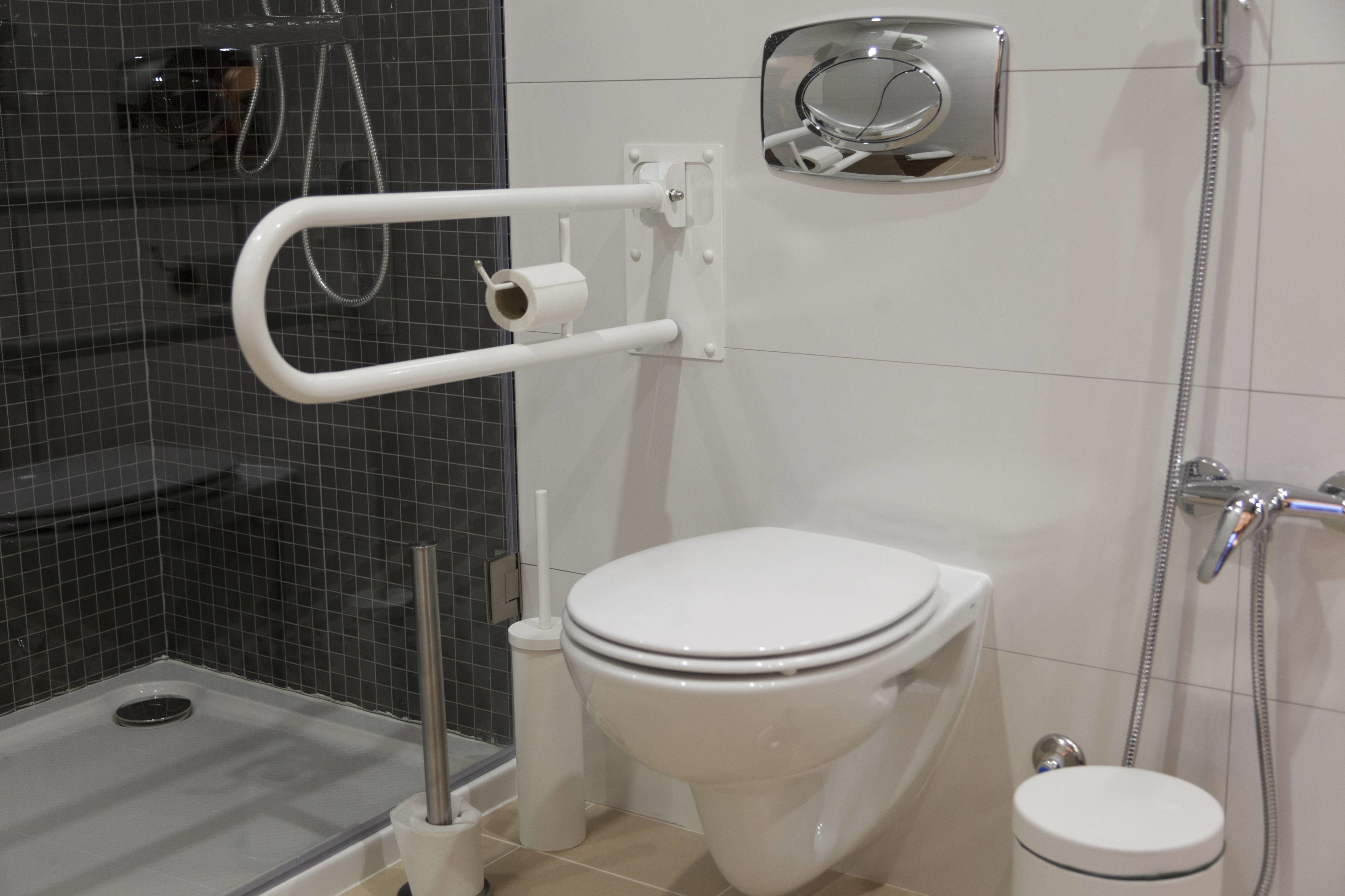 A modern bathroom with a white toilet, a shower area, and a bidet.