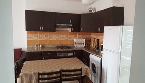 Apartamento, 2 quartos | Cozinha privada | Geladeira grande, micro-ondas, fogão, cooktop
