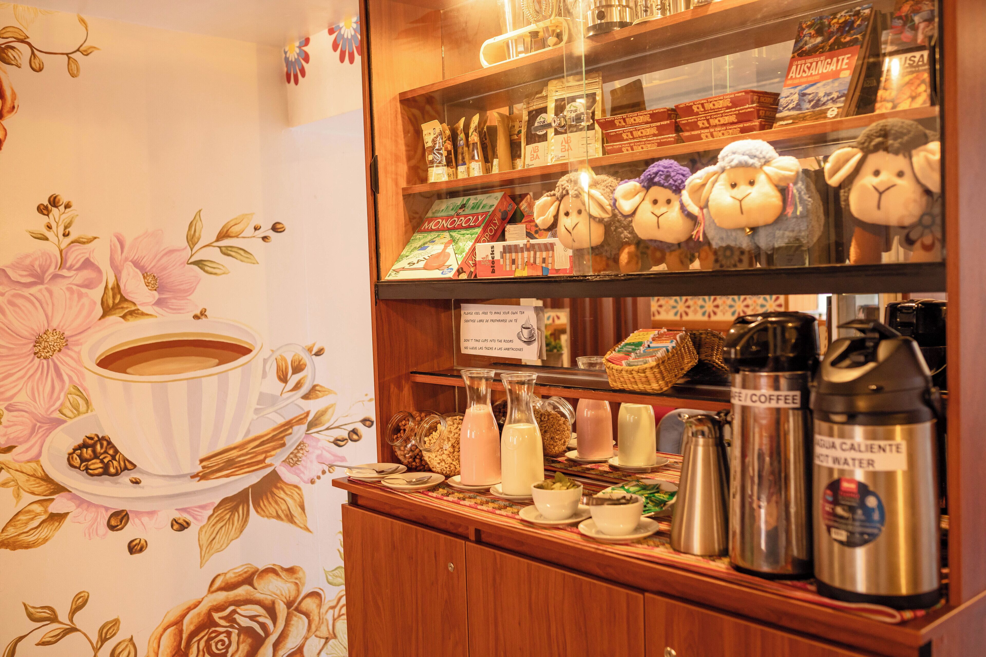 Eine Theke in einem Café mit verschiedenen Kaffees- und Teesorten, darunter eine Kaffeemaschine und Thermoskannen.