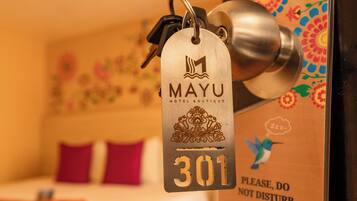 A hotel room with a bed, a door with a keycard, and a sign requesting guests not to disturb.