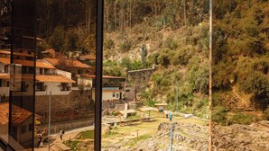 A view from a window overlooking a hillside with buildings and a rocky area. - Mayu Boutique Hotel (Cusco)