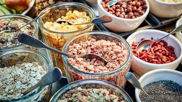 Diversa variedad de alimentos como frutas, nueces y granos.