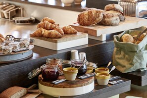 A breakfast buffet with pastries, jams, and condiments. - 25hours Hotel The Circle (Cologne)