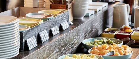 A buffet with various food items including fruits and vegetables.