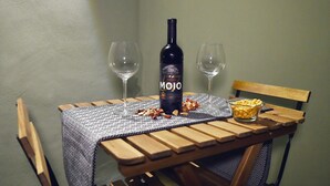 A wooden table with a bottle of wine, two glasses, and a bowl of snacks. - Maschio Angioino Suite (Naples)