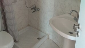Un baño con ducha, inodoro y lavamanos.