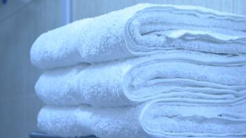 A stack of white towels on a metal shelf.