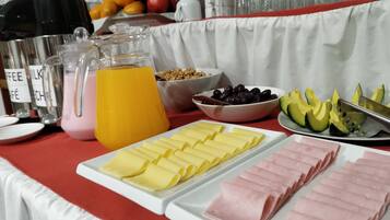 Um buffet de café da manhã com diversas opções de alimentos e bebidas.