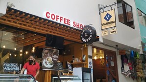 A coffee shop with a sign reading "Coffee Shop" and another sign for "Viandina Machupichu" offering crepes and coffee. - Viandina Machupicchu (Machu Picchu)