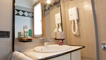 A bathroom with a white sink, a mirror, and a towel rack.