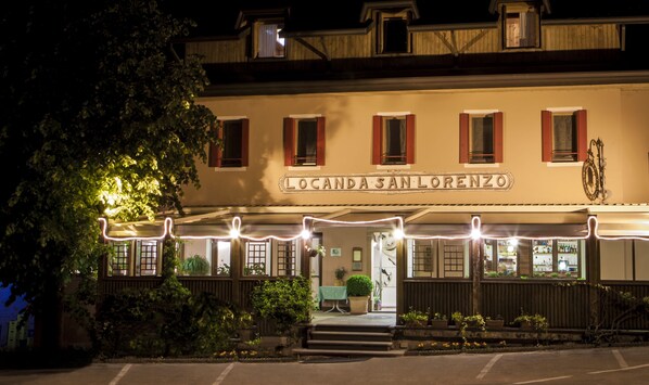 A building with a sign reading "Locanda San Lorenzo" at night.