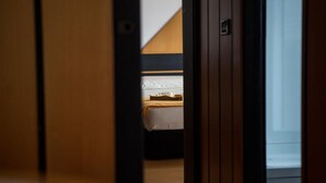 A narrow hallway leading to a bedroom with a bed and a nightstand. - Locanda San Lorenzo (Alpago)