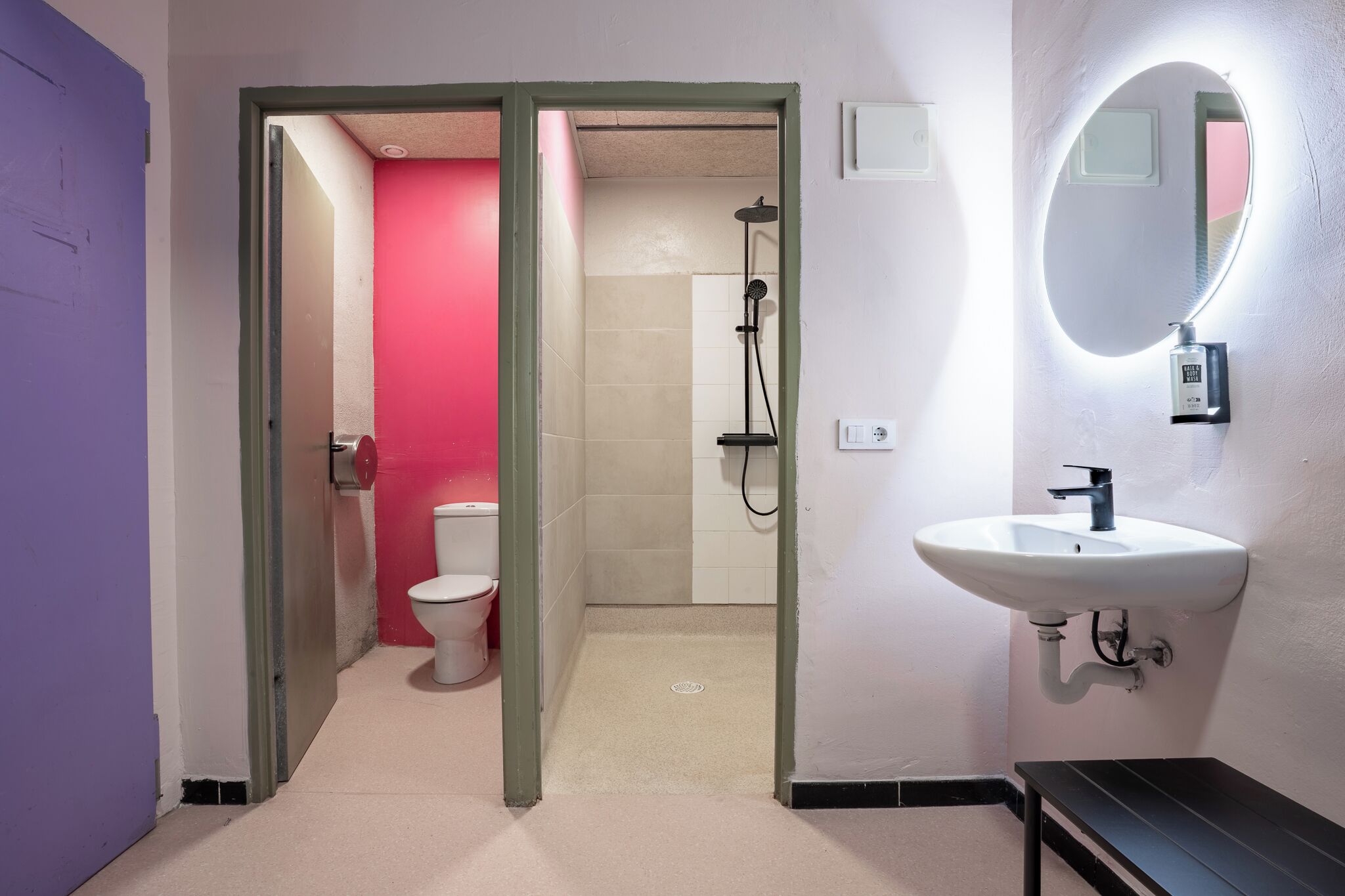 Une salle de bain avec un lavabo blanc, un miroir et une douche.