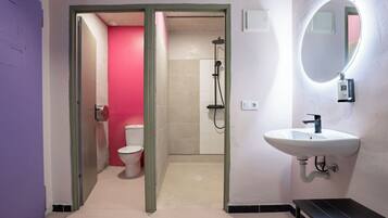 Une salle de bain avec un lavabo blanc, un miroir et une douche.