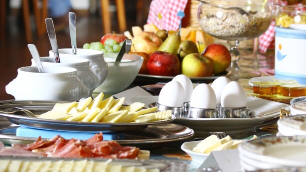 A breakfast buffet with various food items and utensils.