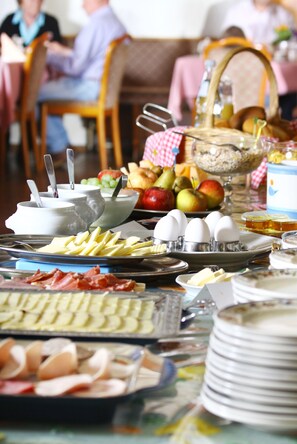 Een ontbijtbuffet met diverse soorten eten en bestek.