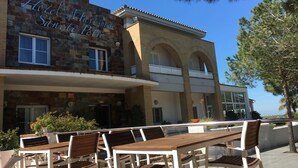Hotel Marisma Sancti Perri with outdoor seating and a stone facade. - Hotel Marisma Sancti Petri (Chiclana de la Frontera)