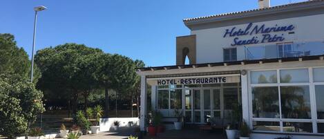 Ein Hotel mit einem Schild, auf dem "Hotel Marino Santi Petri" und "HOTEL RESTAURANTE" steht, was ein Restaurant im Erdgeschoss anzeigt.