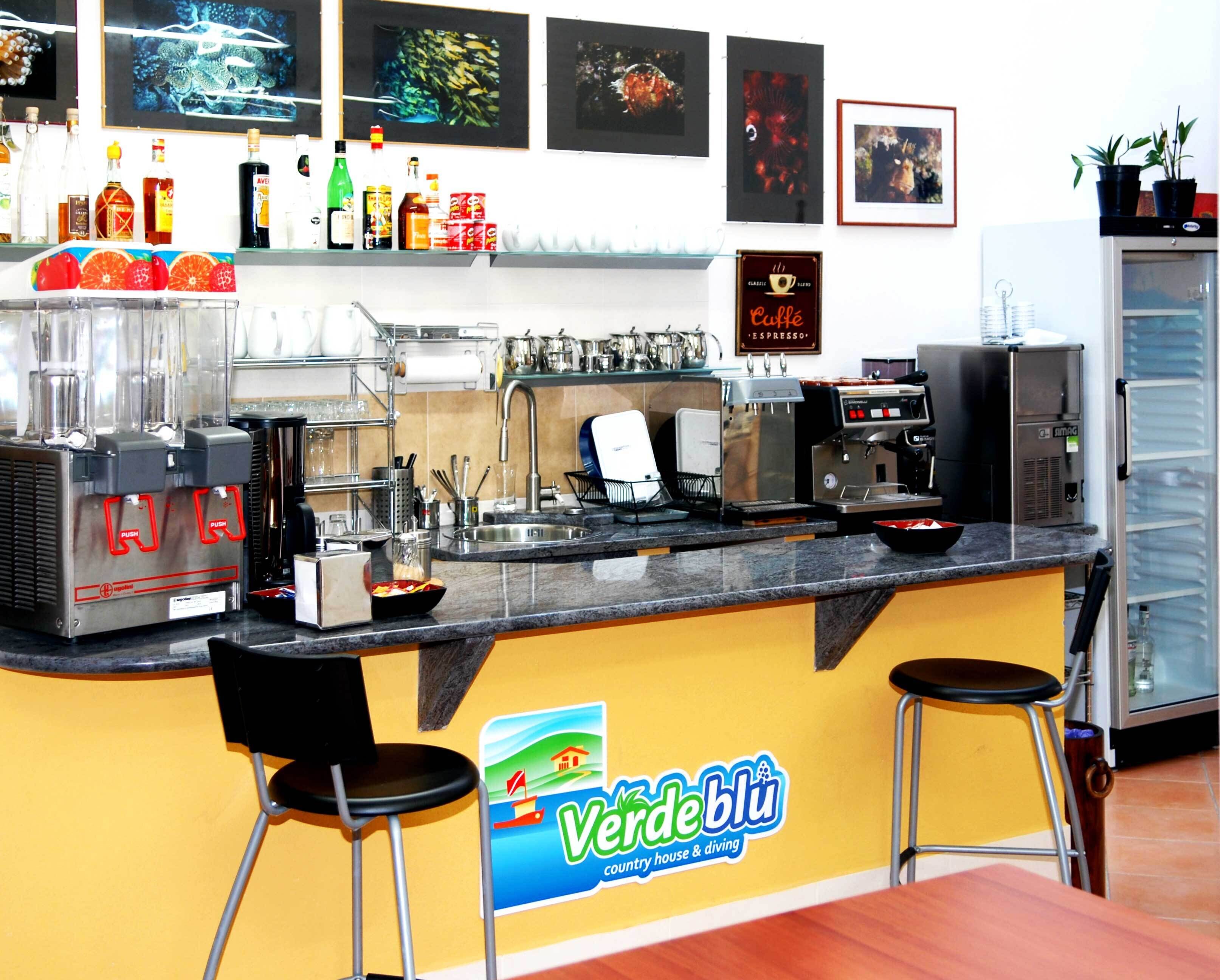 Una cafetería con un letrero de la marca, máquina de espresso y zona de estar.