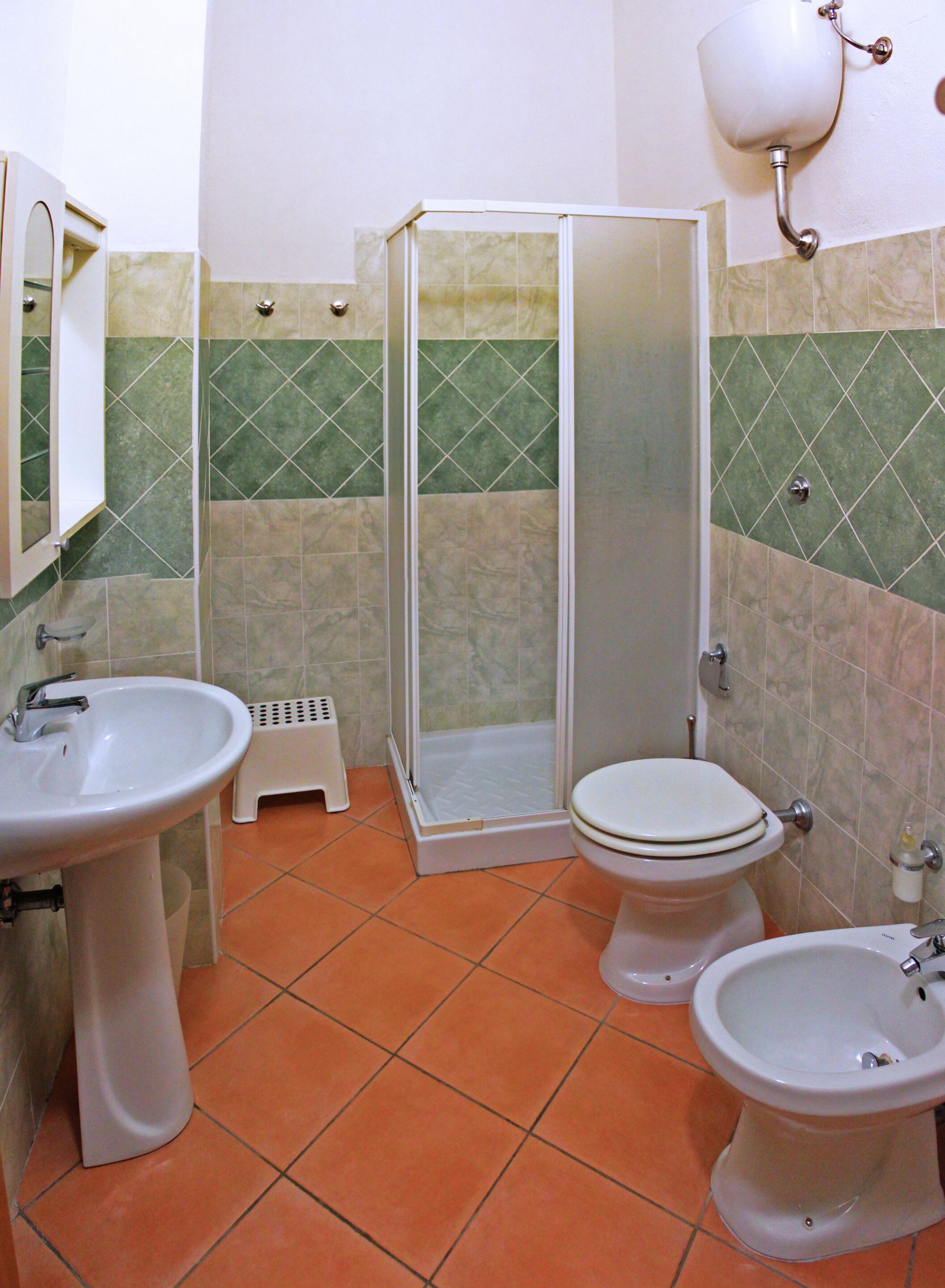 Une salle de bain équipée d’une douche, de toilettes, d’un bidet et d’un lavabo.