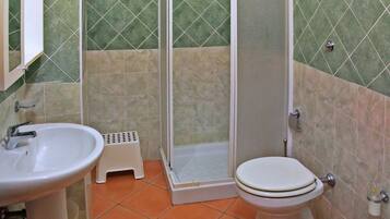 Ein Badezimmer mit Dusche, Toilette, Bidet und Waschbecken.