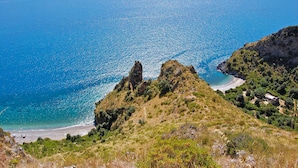 A coastal landscape with rocky terrain and a beach. - Verdeblu House (San Giovanni a Piro)