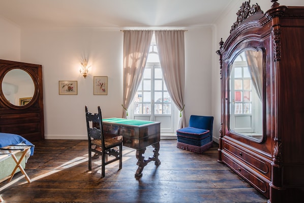 A room with a billiards table, a large mirror, a blue armchair, and a wooden cabinet. - Palazzo Marigliano (Naples)