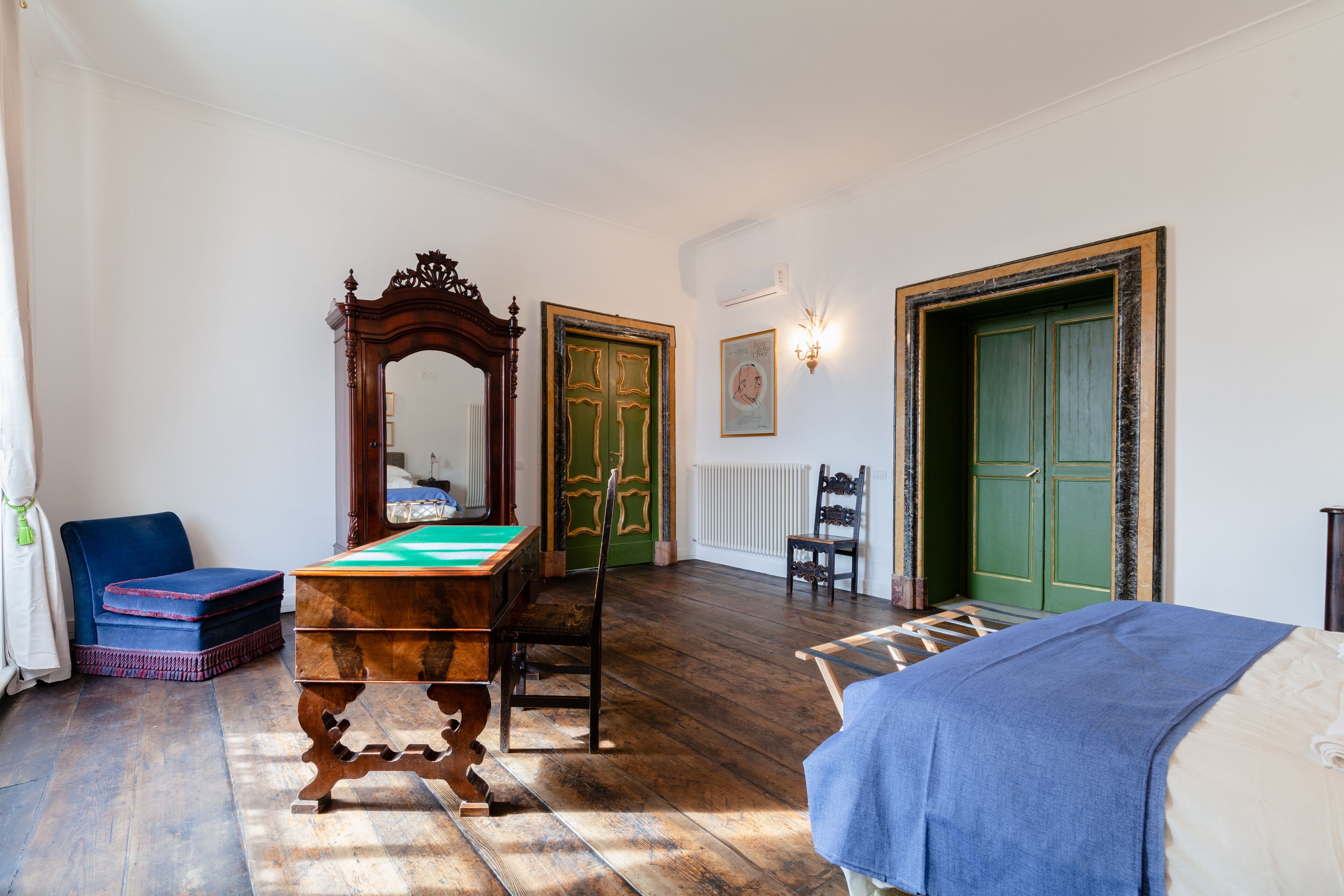 Ein Zimmer mit Poolbillard, Spiegel, grüner Tür, Bett und Stuhl.