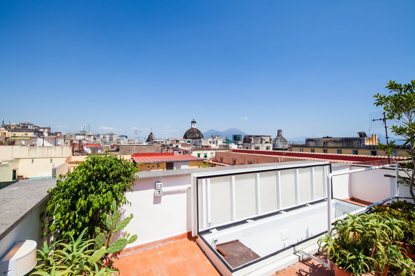 A rooftop terrace with a view of a cityscape, including a prominent dome structure.
