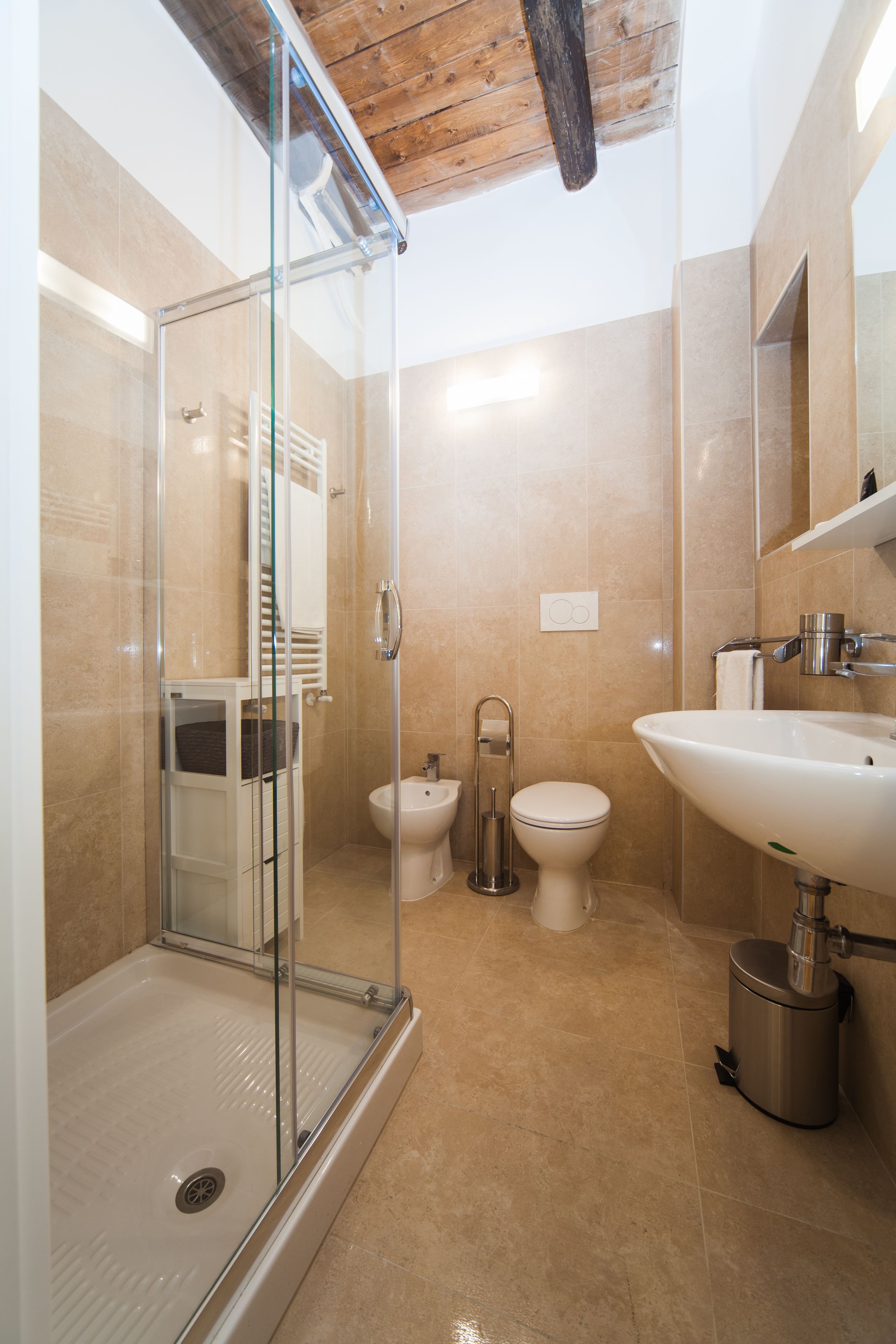 A modern bathroom with a glass shower enclosure, a white sink, and a toilet.
