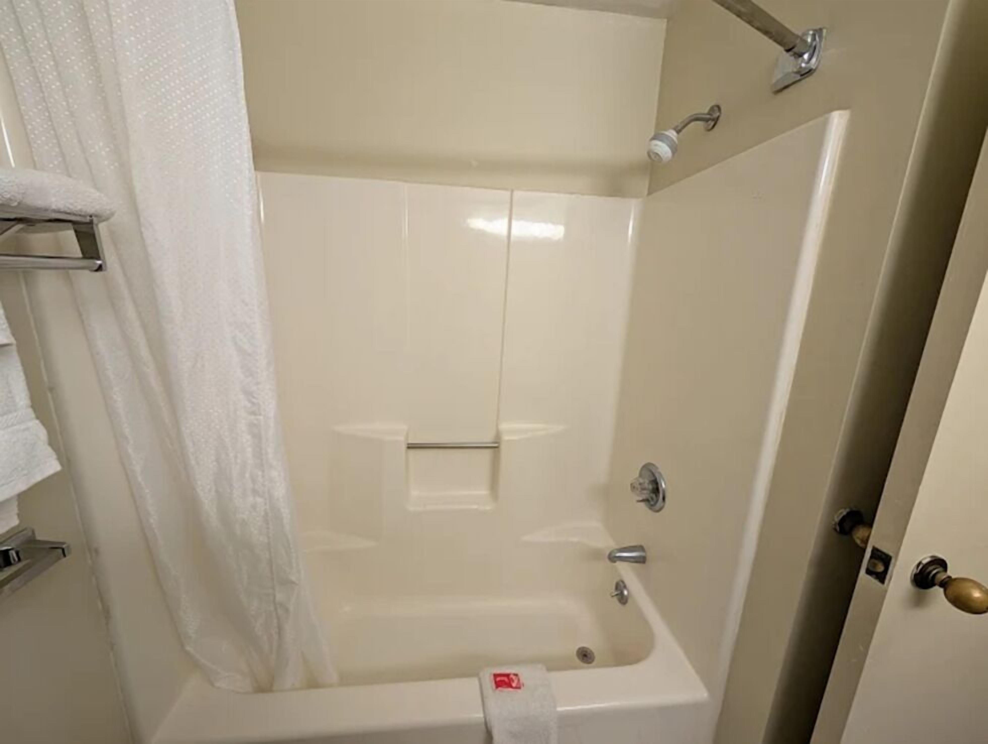 Un baño con bañera, ducha y retrete.