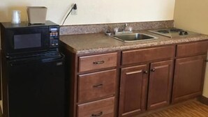 Una cocina compacta con microondas, fregadero y armarios de madera.