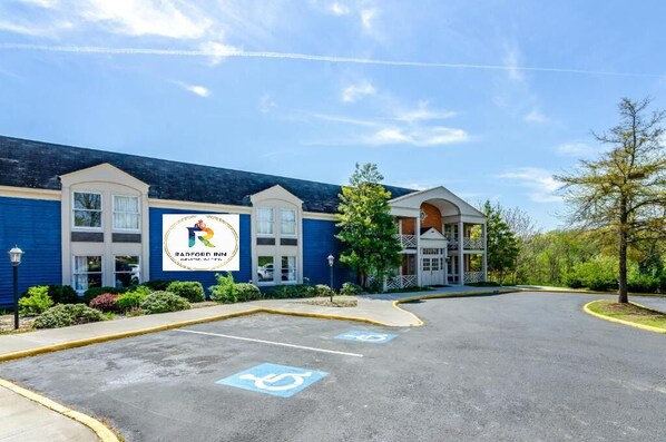 A Radford Inn building with a blue exterior, a parking lot with handicapped parking, and a clear sky.