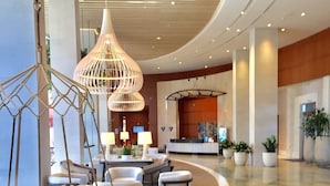 Un vestíbulo amplio con mostrador de recepción, zona de estar e iluminación moderna.