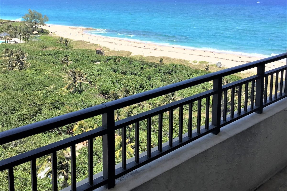 A balcony with a view of a beach and ocean.