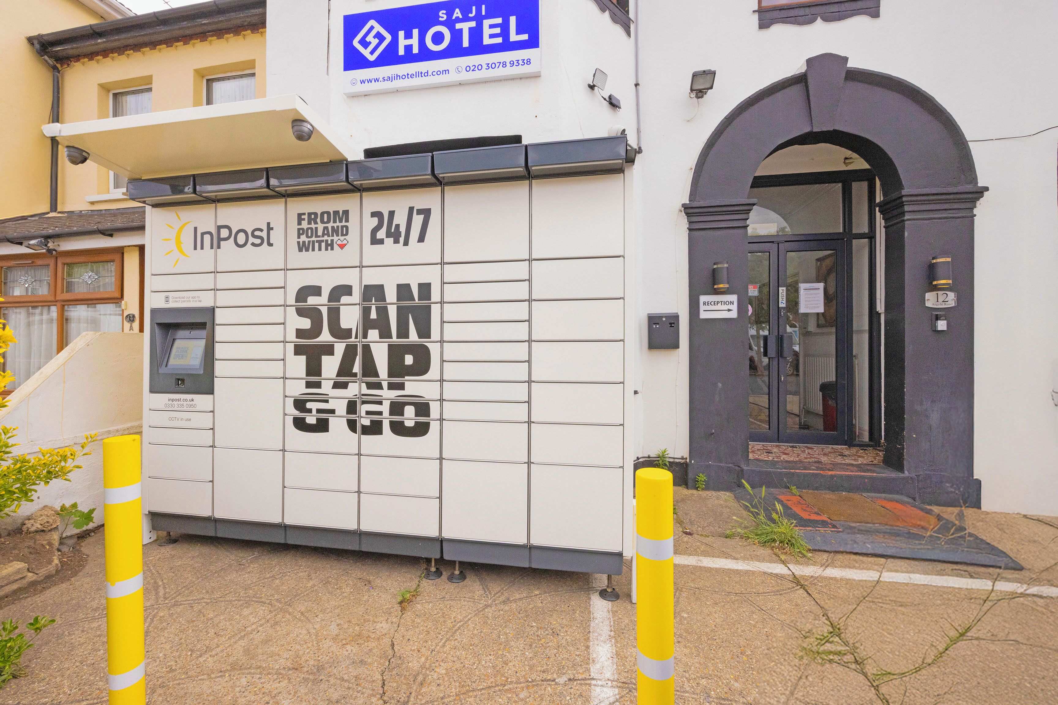 A hotel entrance with a reception desk, a sign for 'Sajl Hotel,' and a 'Scan Tap' machine.
