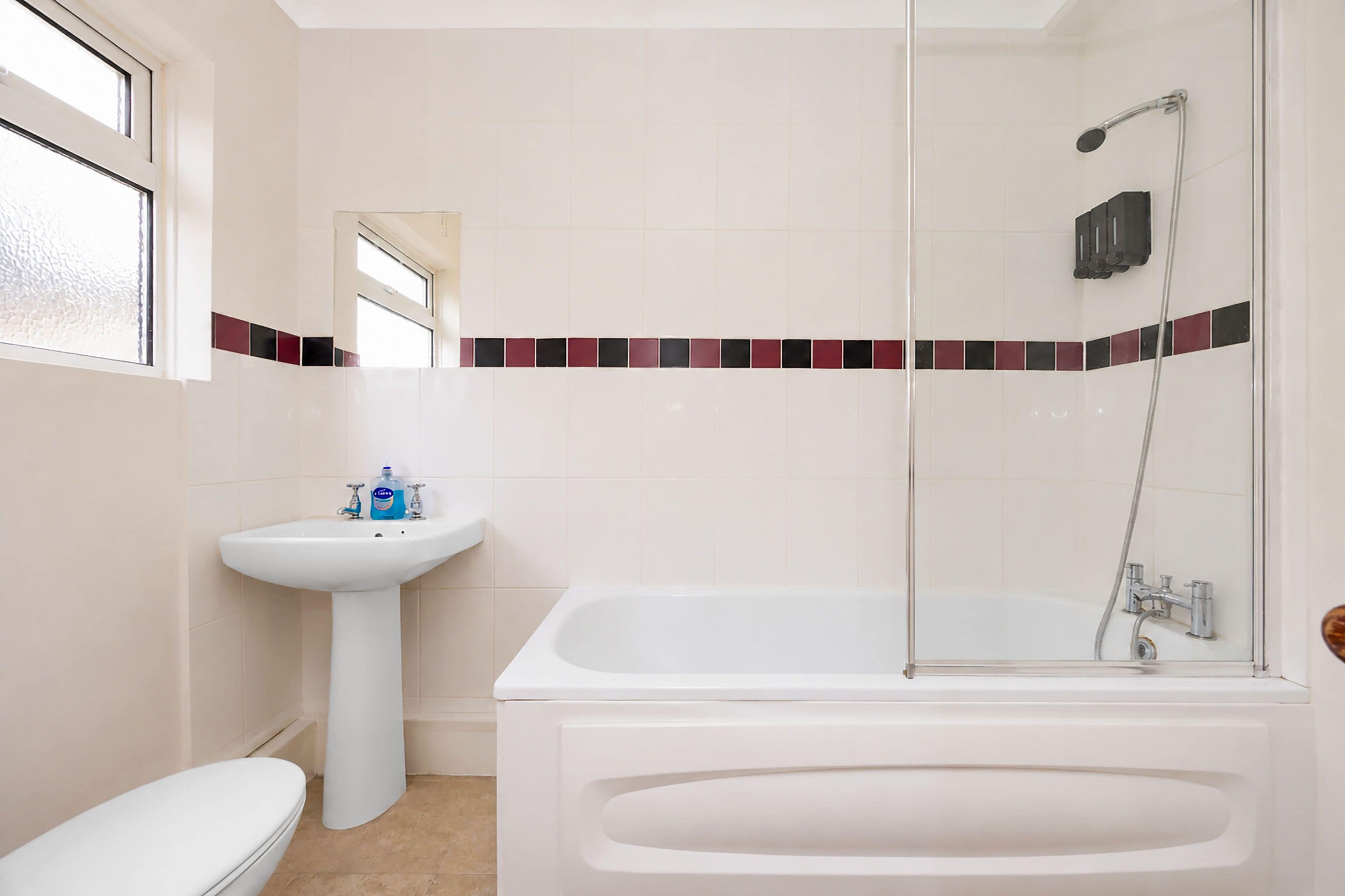 A bathroom with a white sink, toilet, and bathtub.