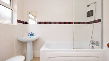 A bathroom with a white sink, toilet, and bathtub.
