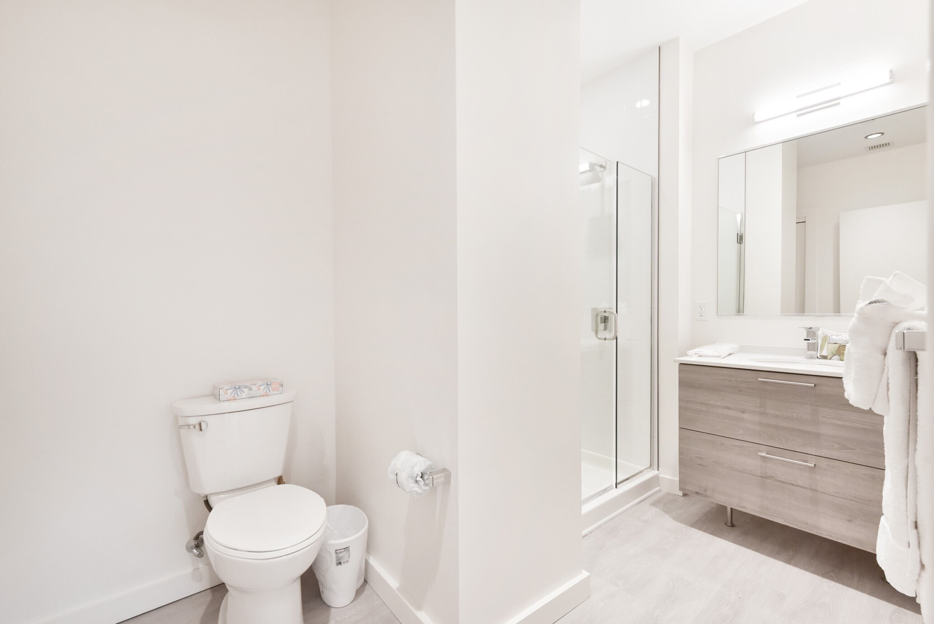 Un baño moderno con inodoro, bidé y cabina de ducha de cristal.