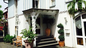 A white building with a sign reading "PARKHOTEL RECEPTION" and a large planter in front. - Parkhotel Fischer (Wernigerode)